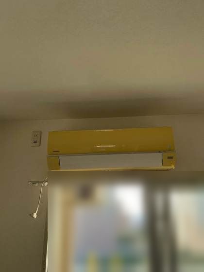 交換前のマンション洋室に設置されていた古いシャープ製エアコン(施工前)
