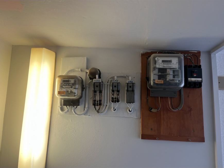 賃貸マンション共用部の電力量計と開閉器盤の設置状況を確認した様子
