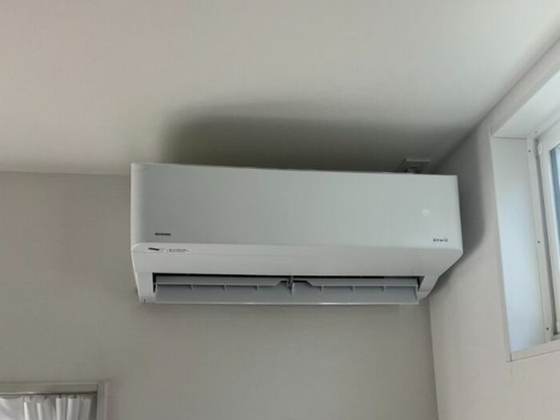 賃貸マンションの居室に新規取付けしたシャープ製エアコン室内機と再利用した室内化粧カバー（施工後）
