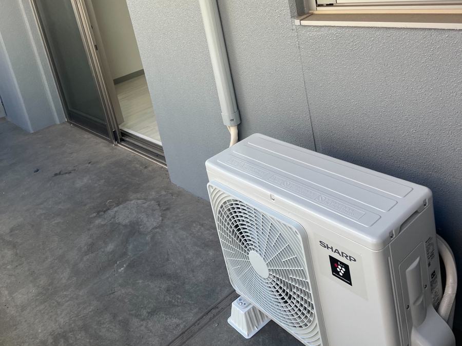 賃貸マンションのベランダに設置したシャープ製エアコン室外機と再利用した室外化粧カバー（施工後）