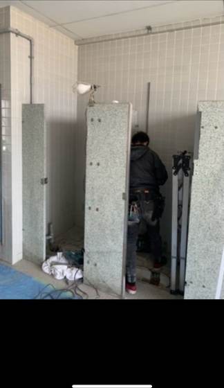 施設の共用トイレでブースを解体し便器を撤去する作業の様子