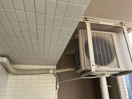 交換前にバルコニー壁面へ吊り設置されていたシャープ製エアコン室外機（施工前）